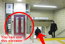 You can use the red elevator on the left side to go down stairs. Then turn left.